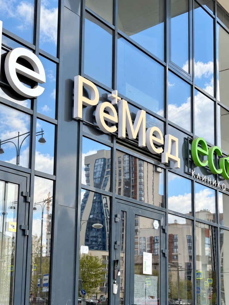 Вывеска РеМед на стеклянном фасаде клиники